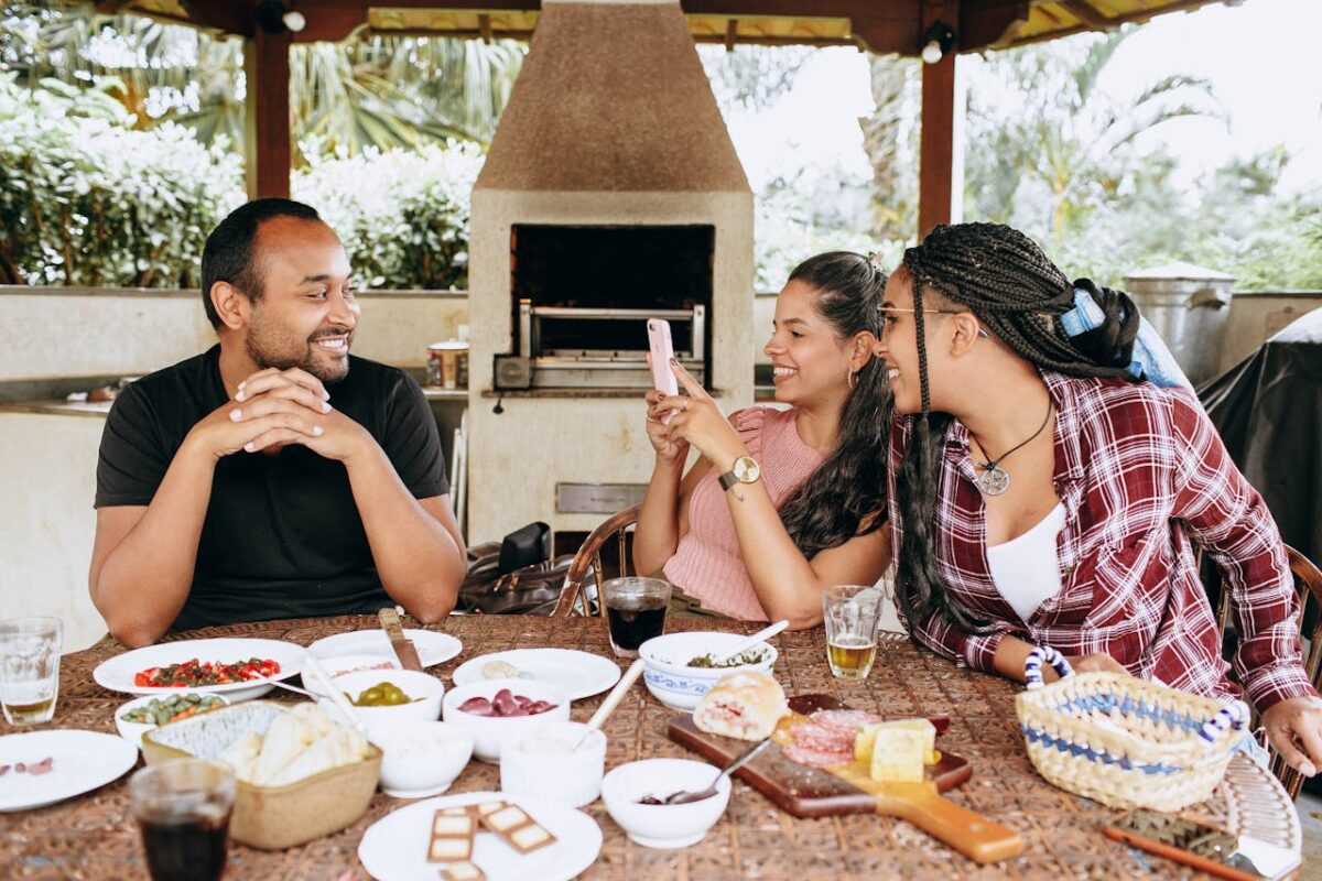Friends enjoying a meal together outdoors, capturing a lively moment of conversation and connection.