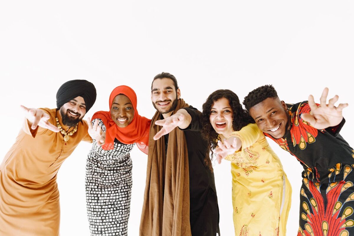 Diverse group of five friends smiling and celebrating together on a white background.